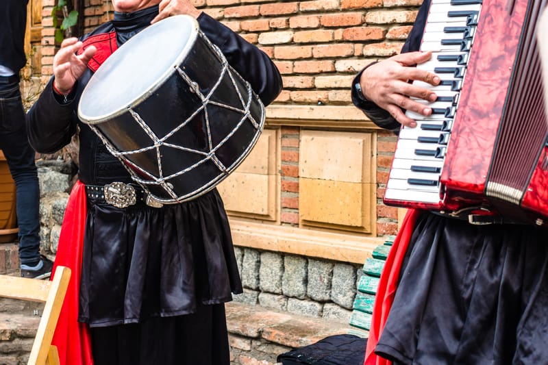 Music fills the air as performers play drum and harmonica in Georgia