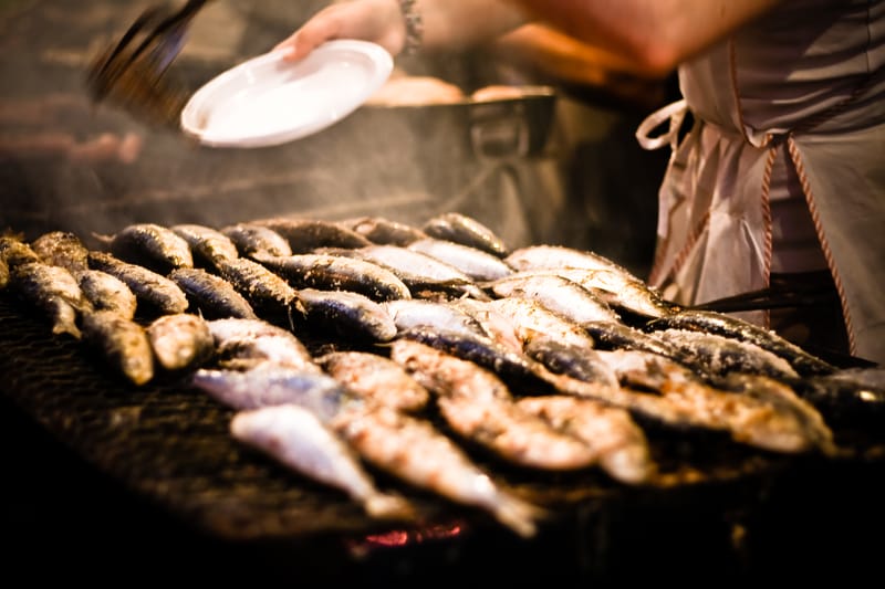 Sardines on a street grill during festival season.