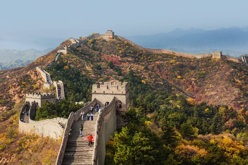 The Great Wall of China at Jinshanling, winding over forested hills with watchtowers along the ridge