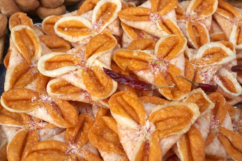 Deep-fried Nepali sel roti piled with saffron strands and dried red chilies.