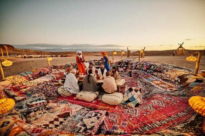 Friends dining at sunset during a Tailormade luxury desert holiday at Agafay Desert Camp in Morocco