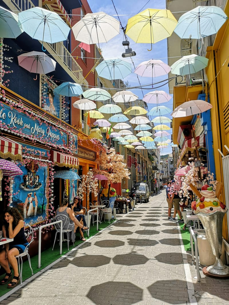 Karaiskaki Street in Monastiraki, Athens, where the whimsical Little Kook caf&eacute; transforms the neighbourhood with seasonal street decorations.