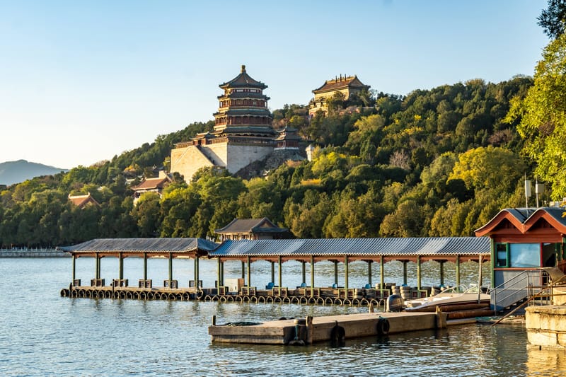 The Summer Palace pagoda reflected across the lake, with trees and park grounds in Beijing
