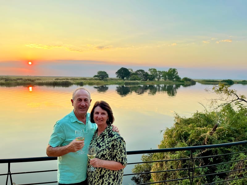 Inspiring Vacations travellers Gary T and his wife enjoying a relaxing sundowner at sunset on their Ultimate Africa tour