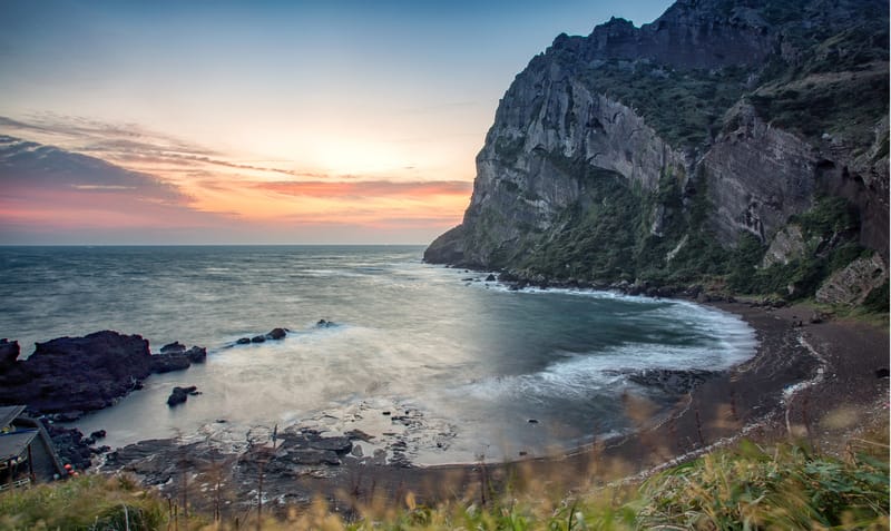 Sunrise over Sunrise Peak on Jeju Island, with the ocean creating a serene landscape