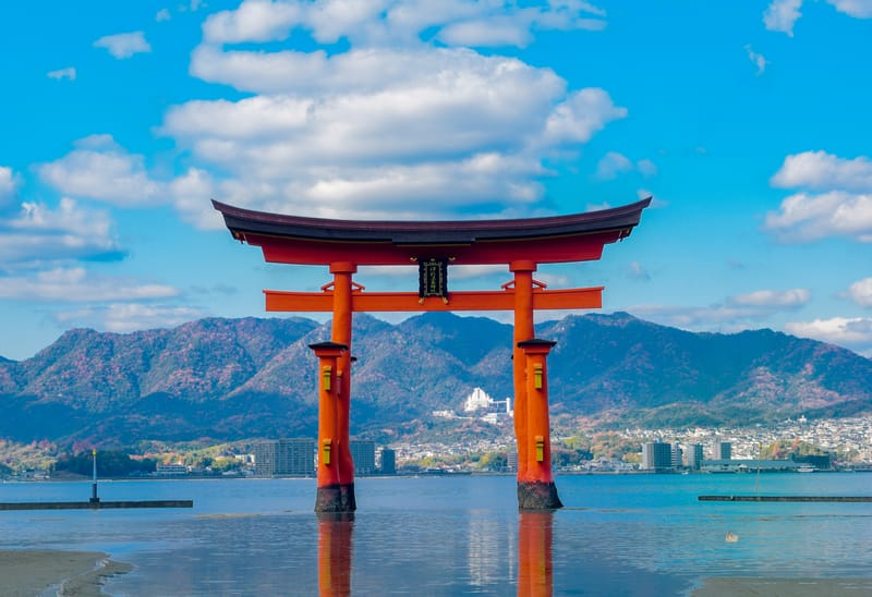 The floating torii gate at Itsukushima Shrine on Miyajima Island on a sunny day with reflections on the water