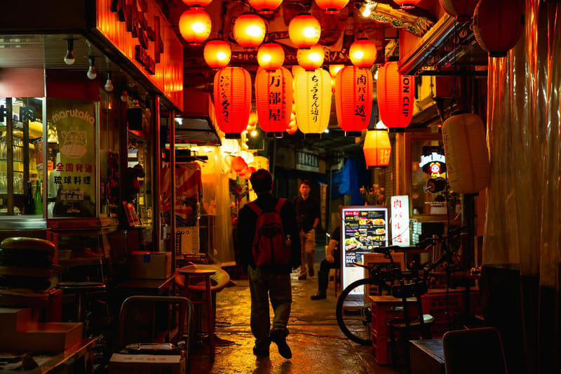 Kokusai Street in Naha after dark, where dinner stretches long and the sanshin keeps playing.
