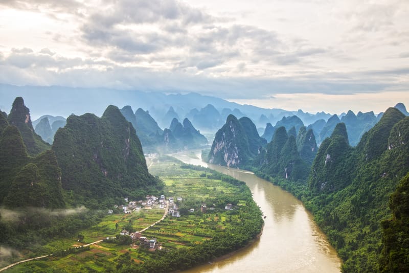 Messire mountains rising above the Li River in Guilin, China, with mist weaving through the peaks