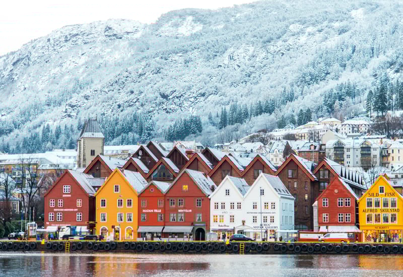 The brightly painted historic houses of Bryggen reflected in Bergen harbour, gateway to Norway's western fjords.