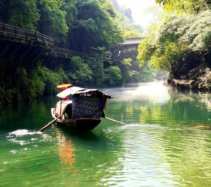 Cruise ship gliding along the Yangtze River with lush green hills in the background