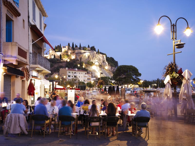Evening falls over Cassis as guests on a culinary tour of France enjoy an alfresco dinner along the harbour
