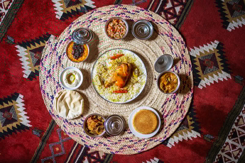 A traditional Saudi spread with spiced rice, grilled meats, and freshly made accompaniments.