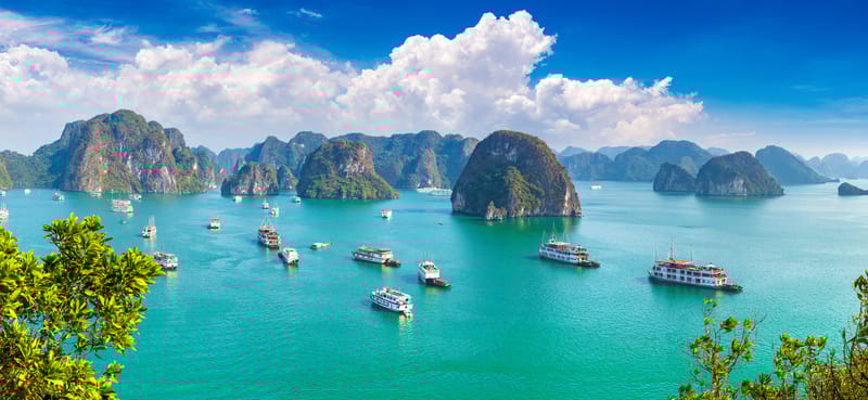 Aerial view of Ha Long Bay, with limestone islands scattered across emerald waters.