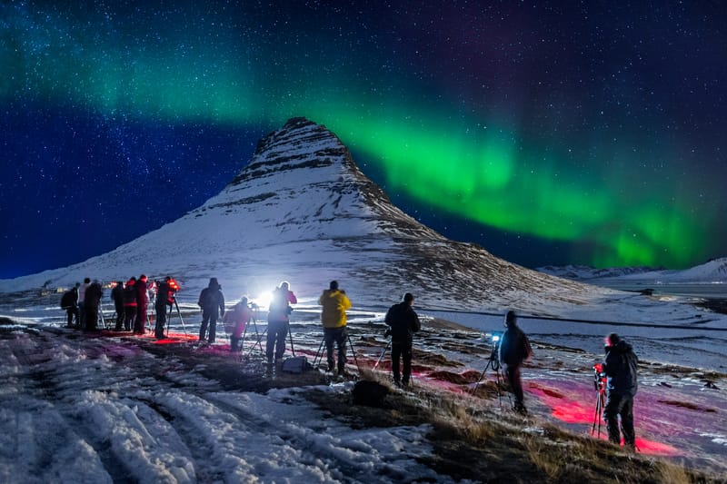 Tourists with cameras and tripods photograph the Northern Lights dancing above Mt Kirkjufell on the Sn&aelig;fellsnes Peninsula in Iceland