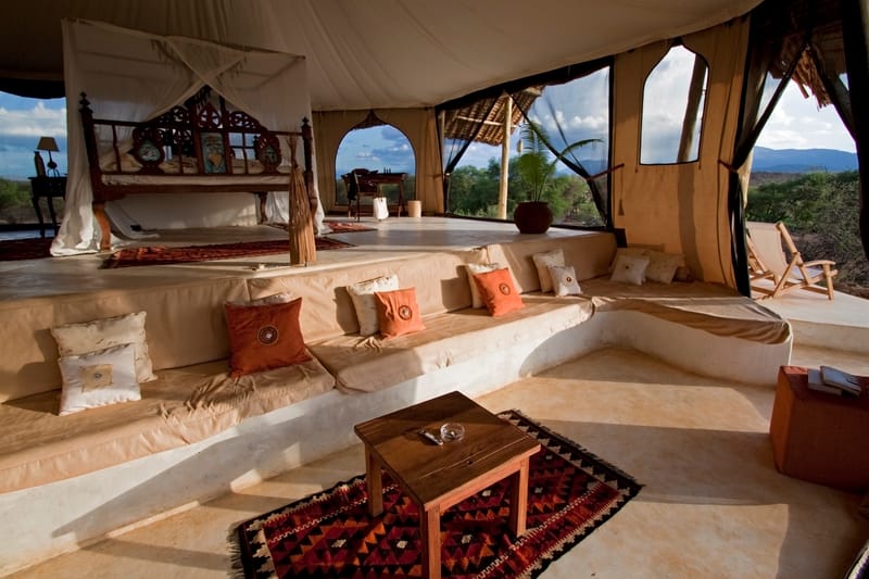 Luxurious safari camp bedroom in warm light, a tranquil setting ideal for a luxury holiday in the wilderness